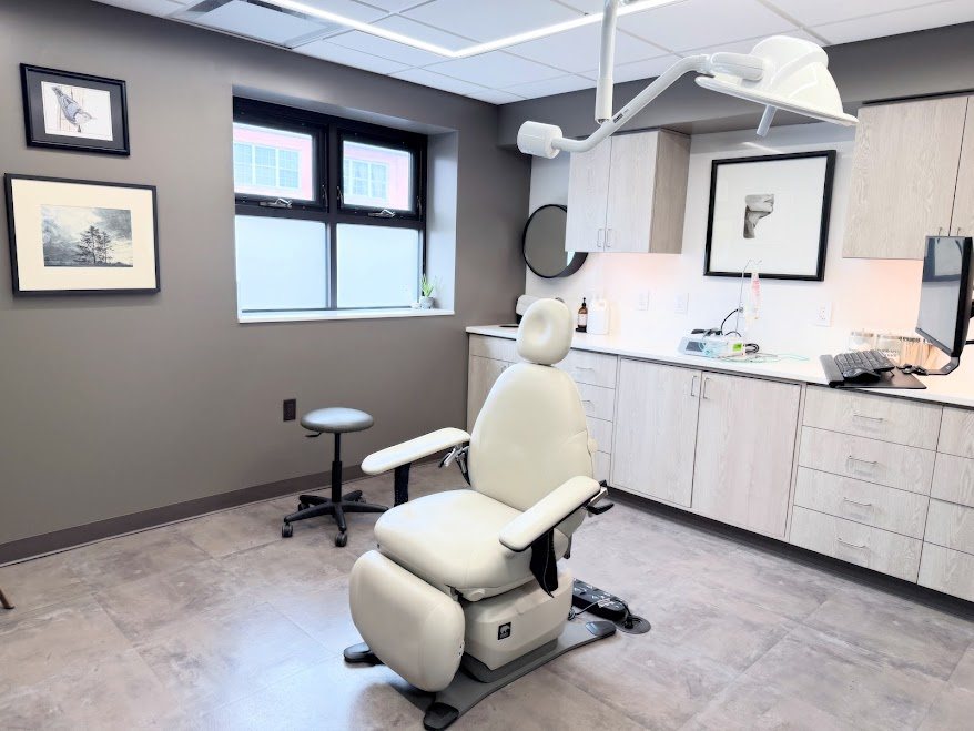 A Refined treatment room with its treatment chair, cabinetry, and natural light